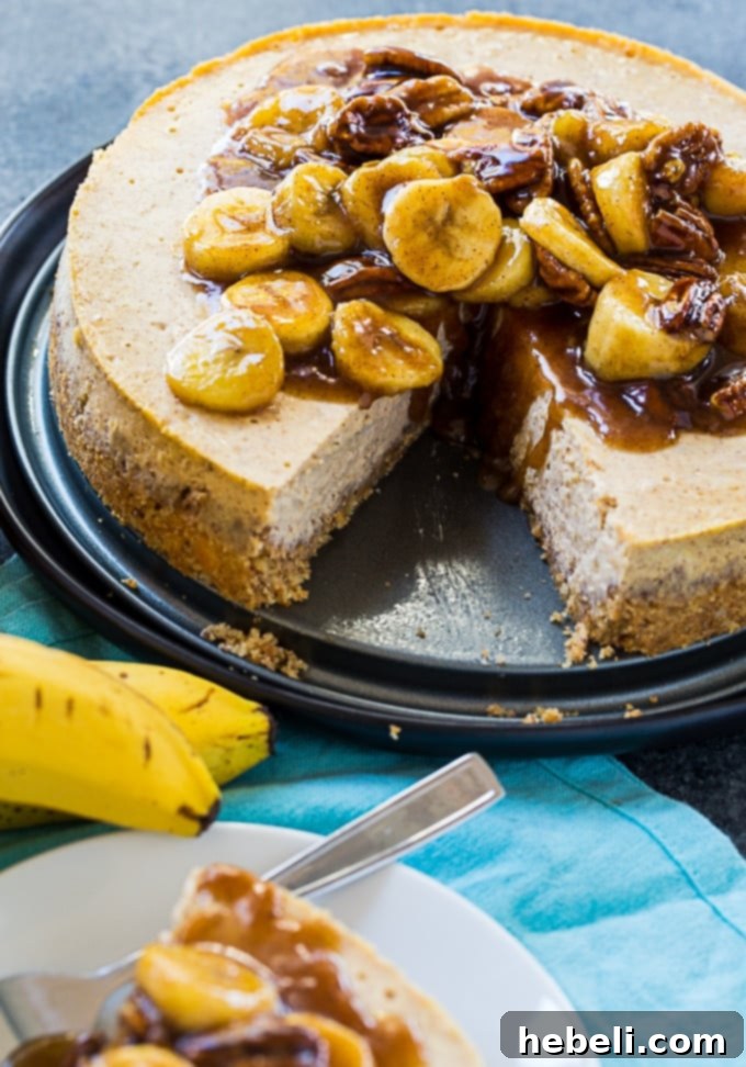 Decadent Bananas Foster Cheesecake 3 A slice of Bananas Foster Cheesecake showing the creamy filling and a rich topping of caramelized bananas and pecans.