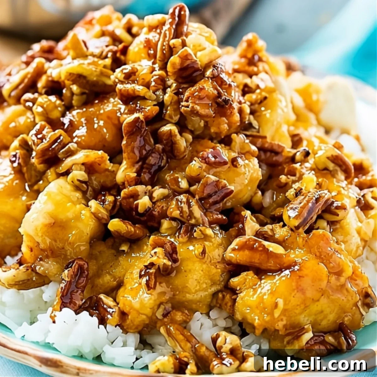 Honey Glazed Pecan Chicken 2 Honey Pecan Chicken served gracefully over steaming white rice, garnished with fresh parsley.