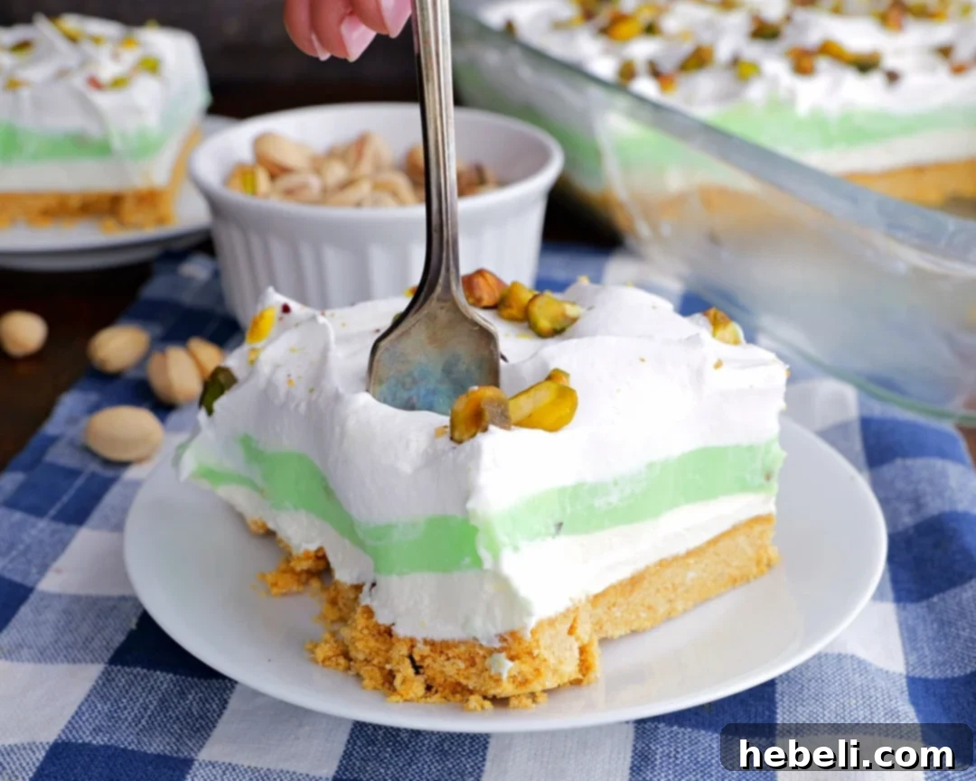 Fork going into a piece of Pistachio Pudding Lush, showing its creamy layers and perfect texture