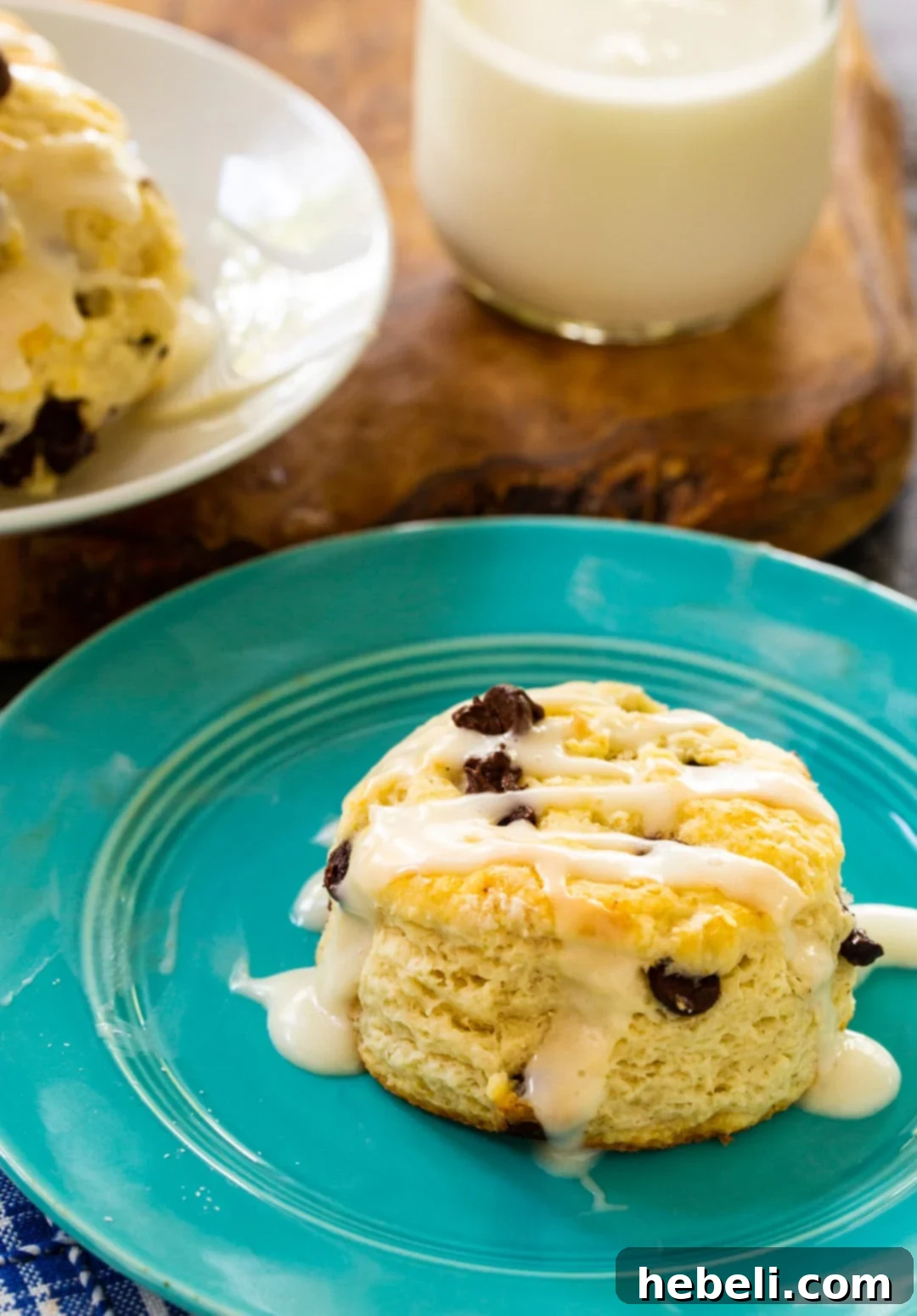 Irresistible Choc-Chip Delights 3 A single chocolate chip biscuit on a plate, showcasing its fluffy interior and glistening glaze.