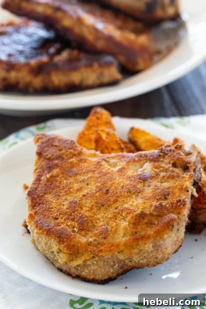Golden fried Ranch Seasoned Pork Chops arranged elegantly on a serving plate, garnished with fresh parsley and lemon wedges