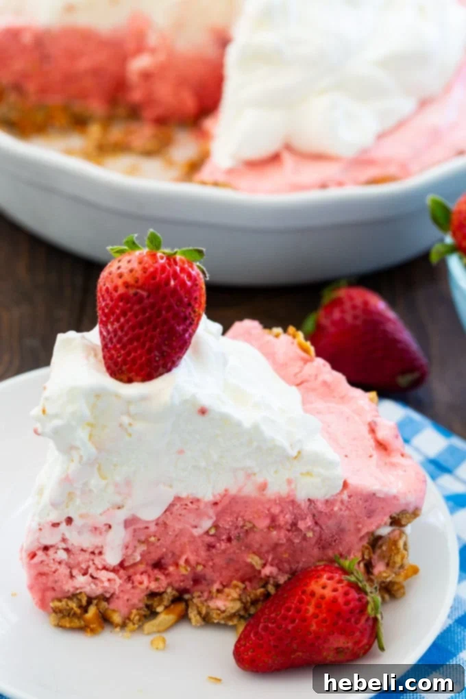 No Bake Strawberry Pretzel Bliss 3 A close-up shot of the entire Strawberry Pretzel Icebox Pie, with one slice already removed, highlighting the layers and inviting texture.