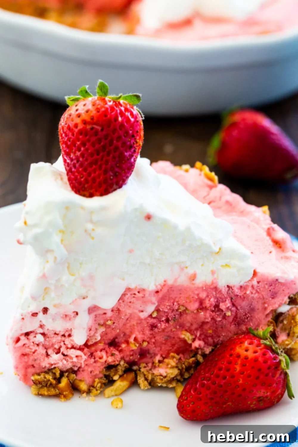 No Bake Strawberry Pretzel Bliss 4 A close-up view of a thick slice of Strawberry Pretzel Icebox Pie, showing the distinct layers of crust, filling, and topping.