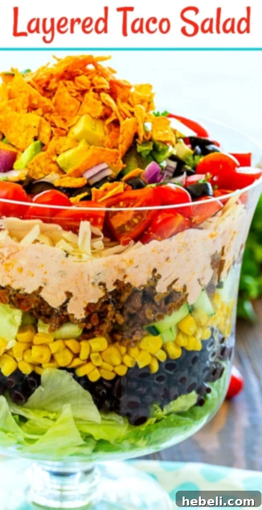 Stacked Taco Salad 8 A vibrant Layered Taco Salad with a mix of fresh ingredients and savory beef, ideal for gatherings.