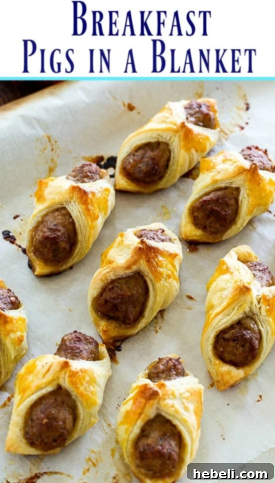 Breakfast Pigs in a Blanket with a light dusting of powdered sugar, showing the flaky pastry texture.
