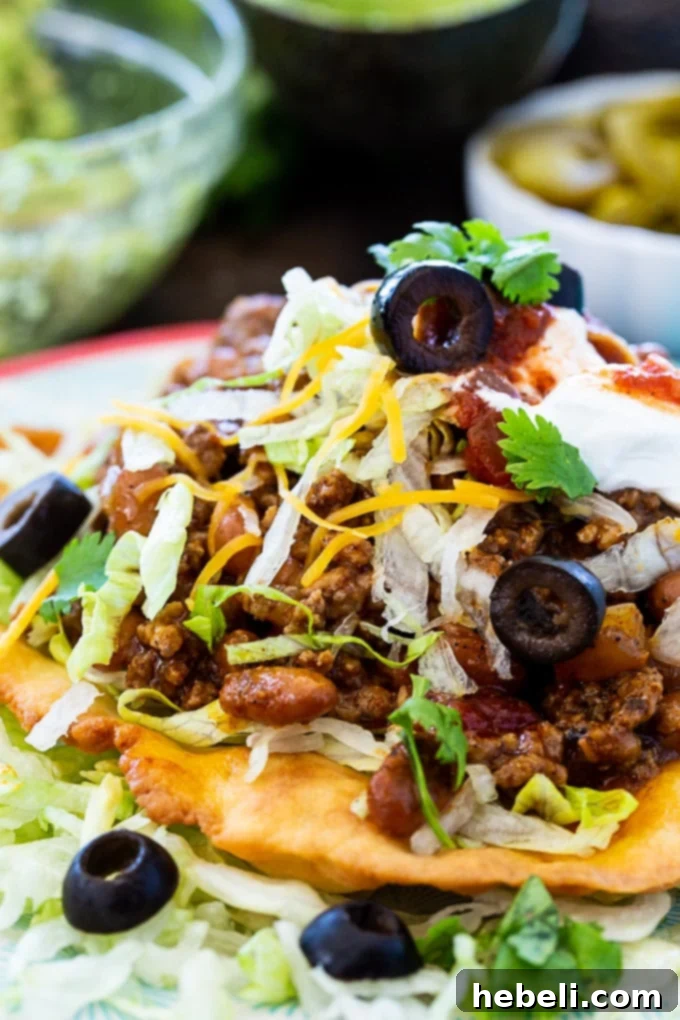 Ultimate Fry Bread Tacos 5 An appetizing close-up of a Fry Bread Taco, showcasing its rich texture and colorful toppings.