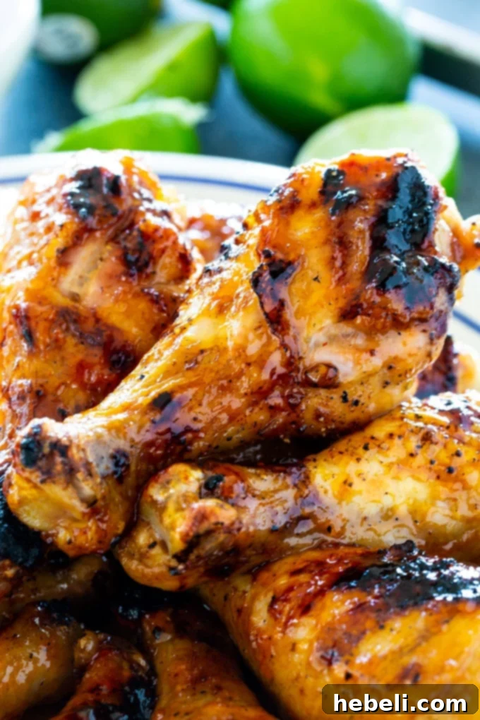 Zesty Jalapeno Lime Chicken Drumsticks 4 Finished plate of glazed Jalapeno Lime Chicken Drumsticks, garnished with fresh lime slices and cilantro.