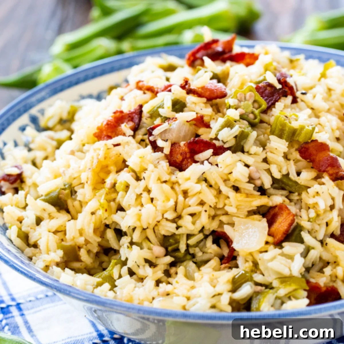 A vibrant bowl of Okra Pilau, showcasing fluffy rice, tender okra, and crispy bacon pieces, ready for serving.