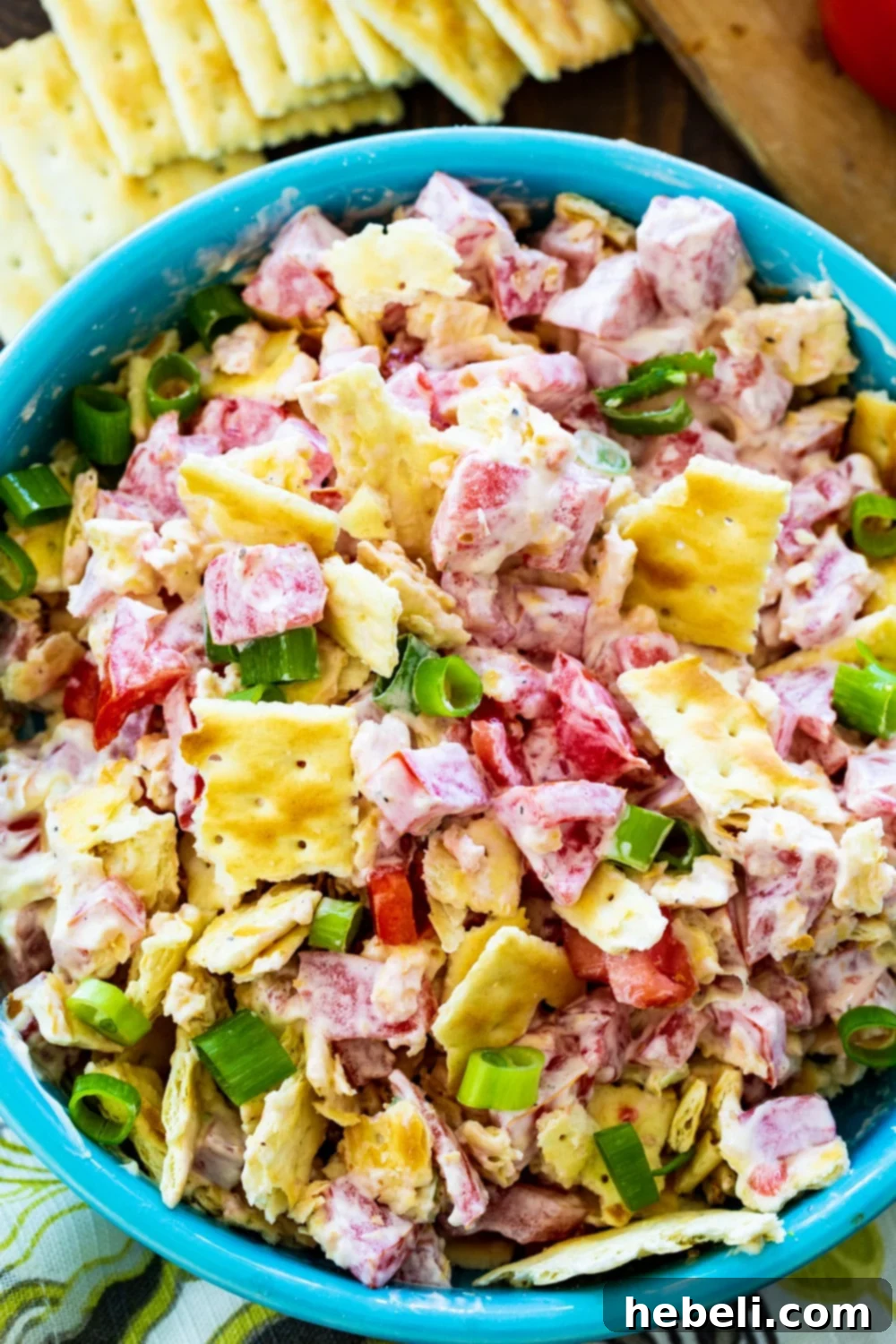 Overhead view of tomato cracker salad in a light blue bowl.