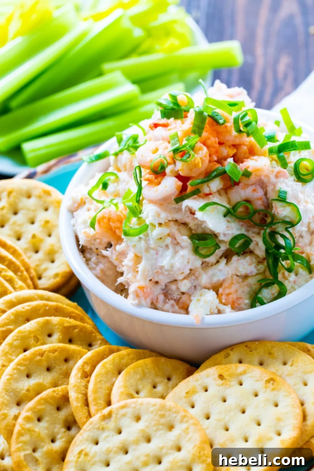 Delicious Easy Shrimp Spread served with various crackers on a rustic wooden board.