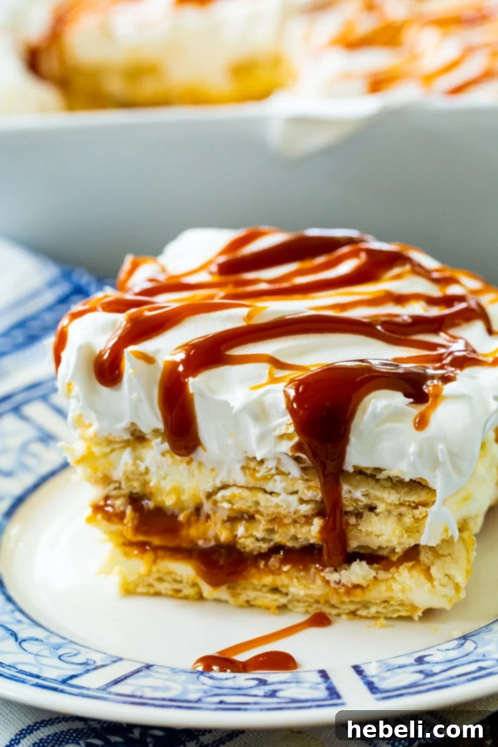 No-Bake Salted Caramel Ritz Cracker Delight 3 A beautiful slice of Caramel Ritz Cracker Icebox Dessert on a white plate, garnished with caramel drizzle.