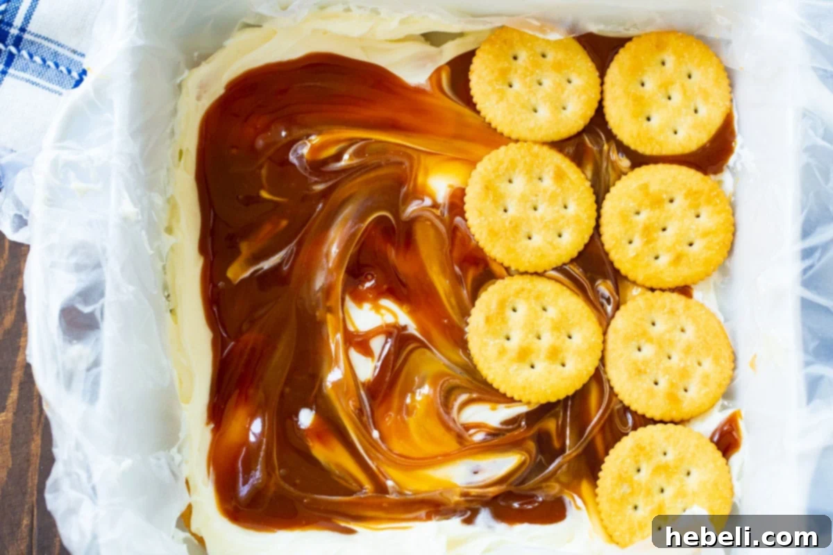 No-Bake Salted Caramel Ritz Cracker Delight 4 Layers of Ritz crackers being arranged on top of caramel sauce in a baking dish.