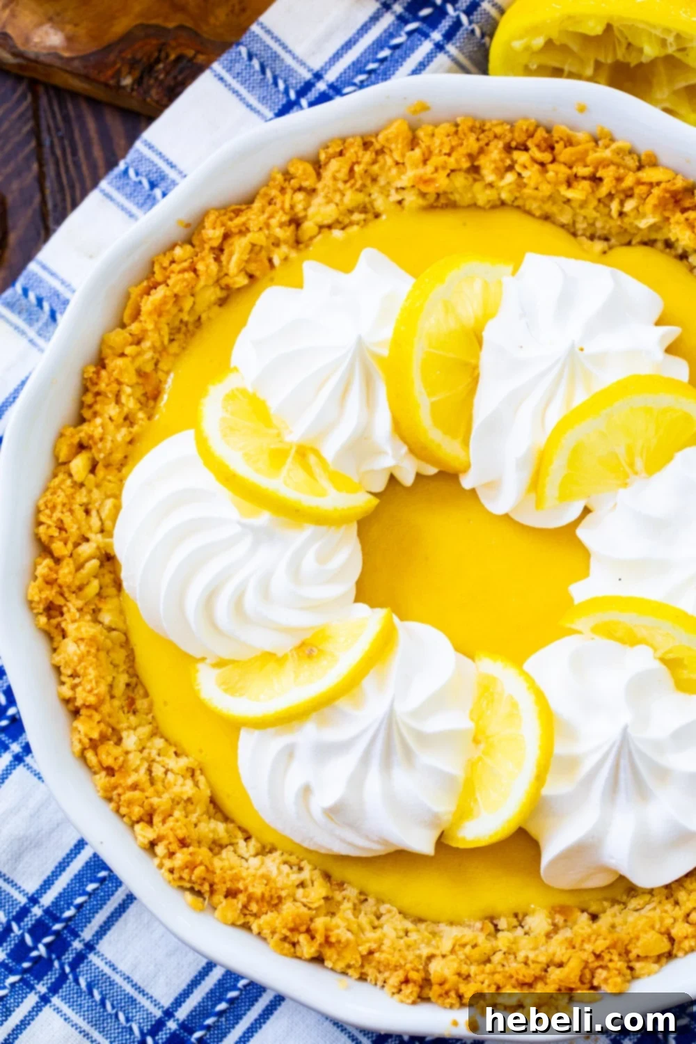 A beautifully presented whole Atlantic Beach Pie, topped generously with fluffy whipped cream and garnished with fresh lemon slices, ready to be served.