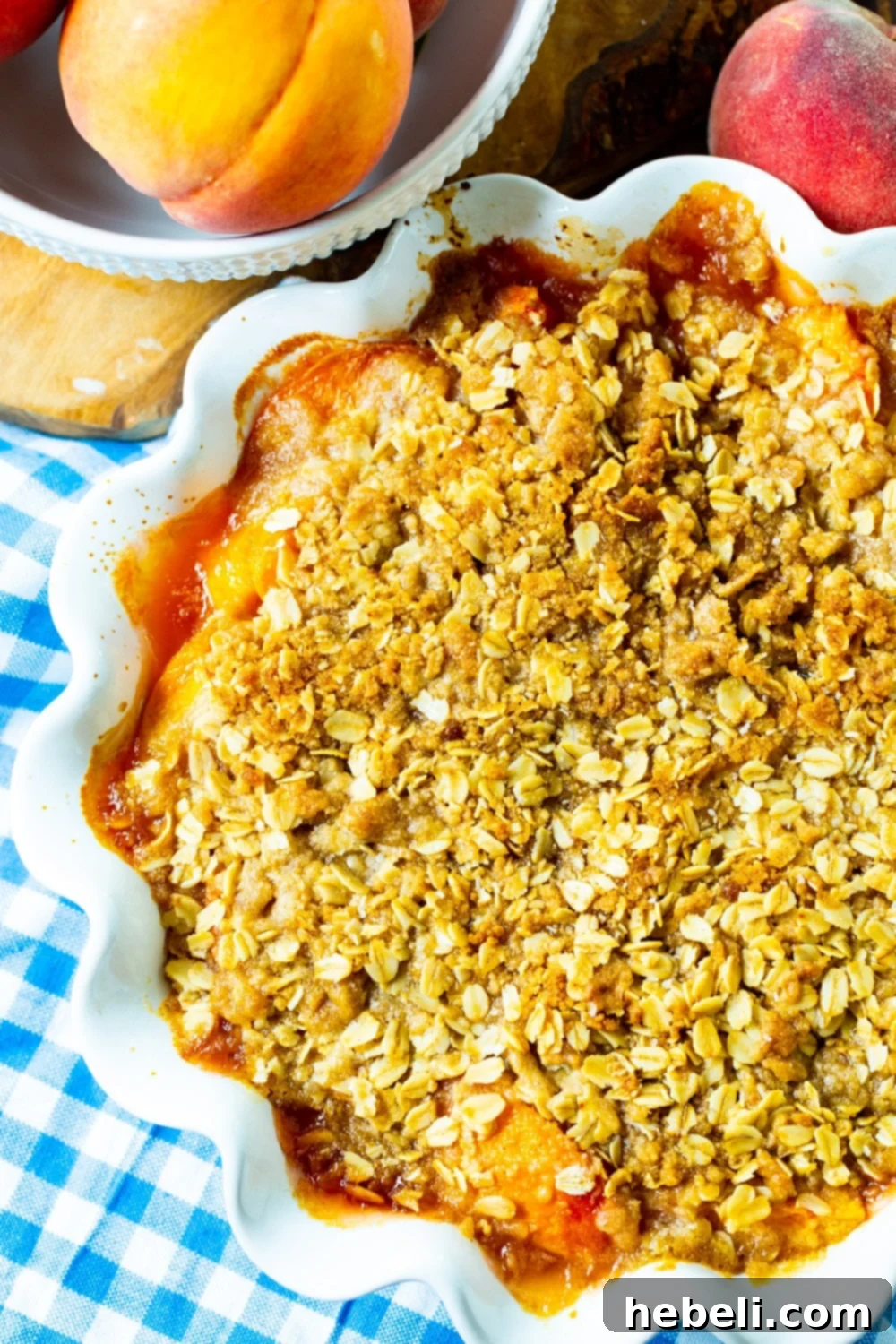 Warm Spiced Peach Bake 3 Overhead of crisp with peaches in a white pie plate.