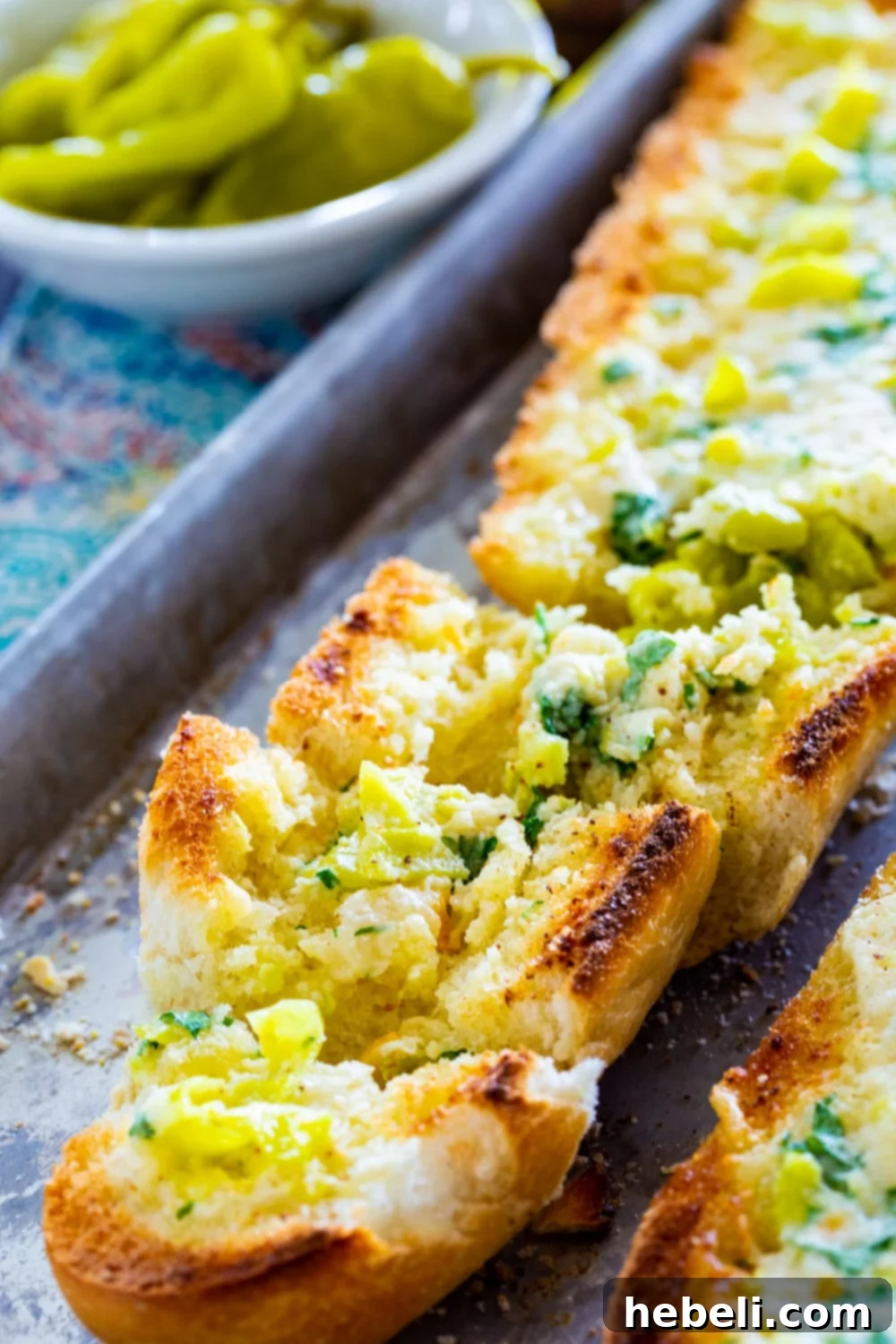 Slices of golden brown Pepperoncini Garlic Bread, showing the crisp edges and flavorful topping.