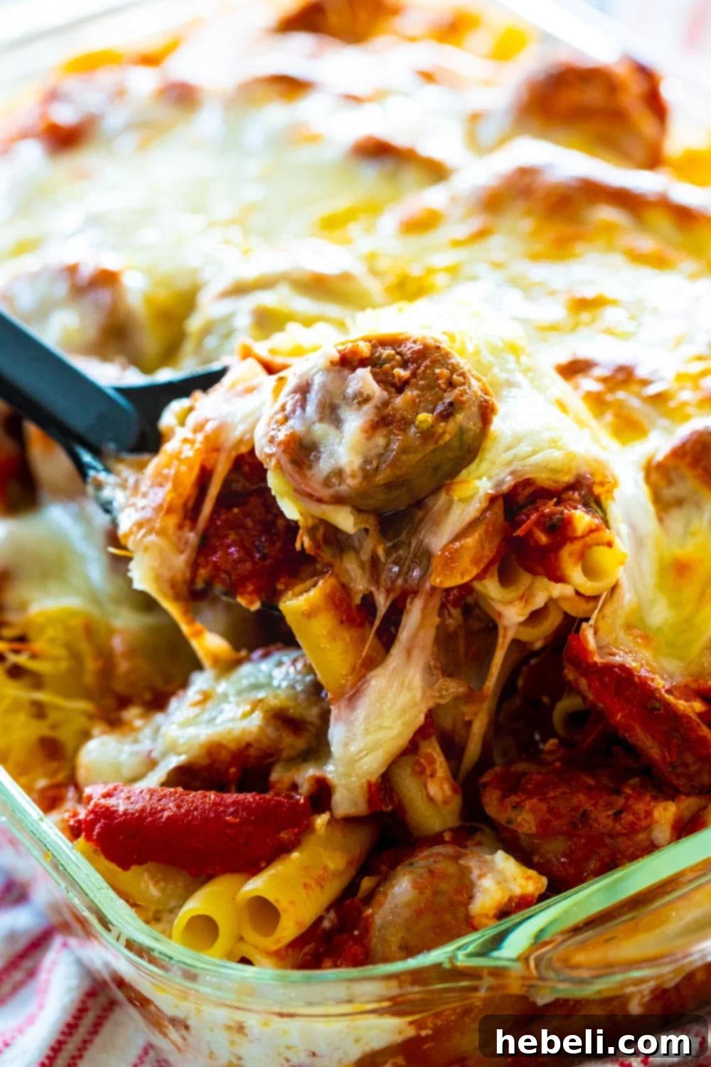 Spoon scooping up Baked Ziti with Italian Sausage.