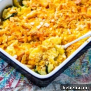 Spoon scooping Cheesy Squash, Zucchini, and Corn Casserole.
