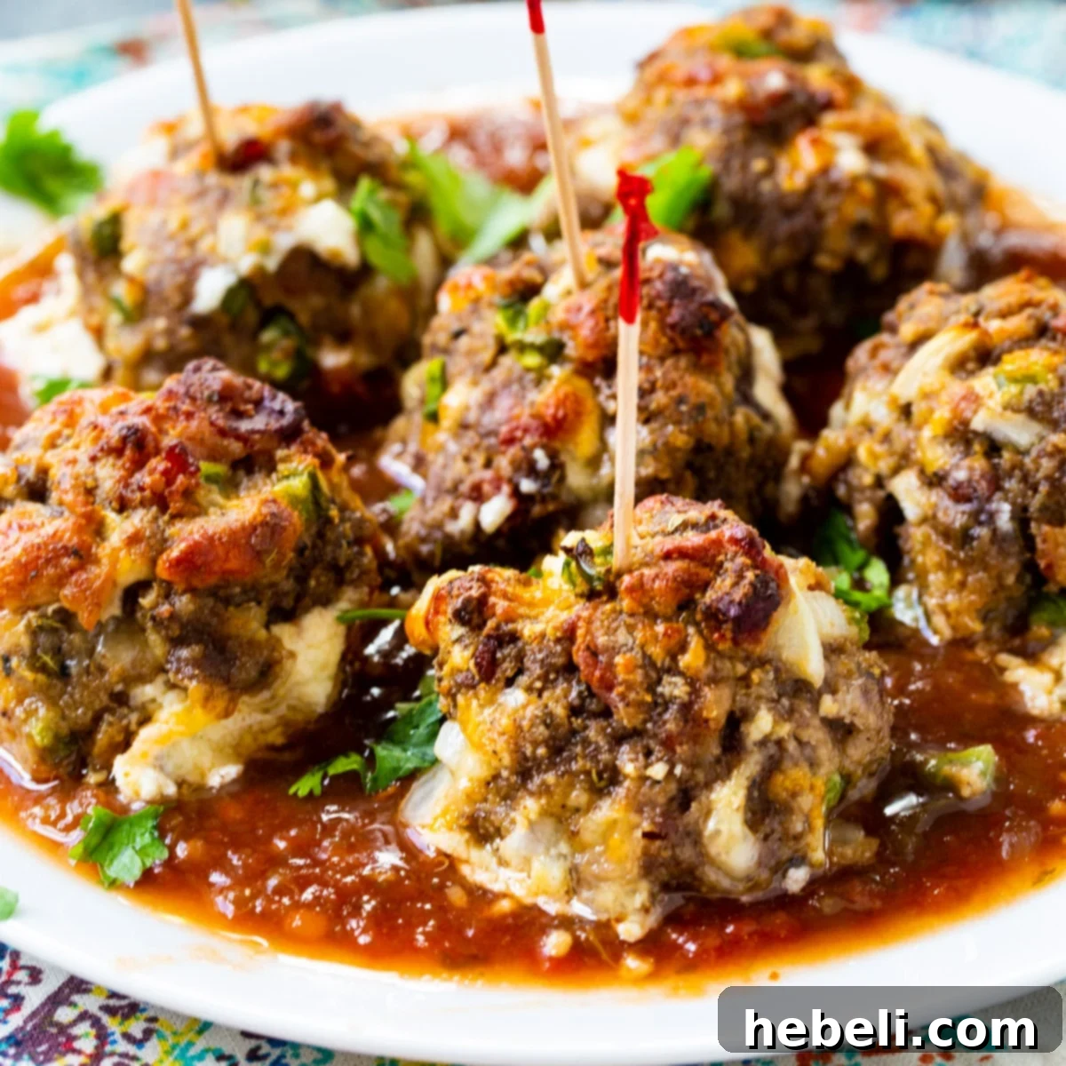Jalapeno Popper Meatballs on a plate with toothpicks stuck in them, ready to be served as an appetizer.