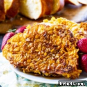 Crunchy French Toast on a plate with raspberries.