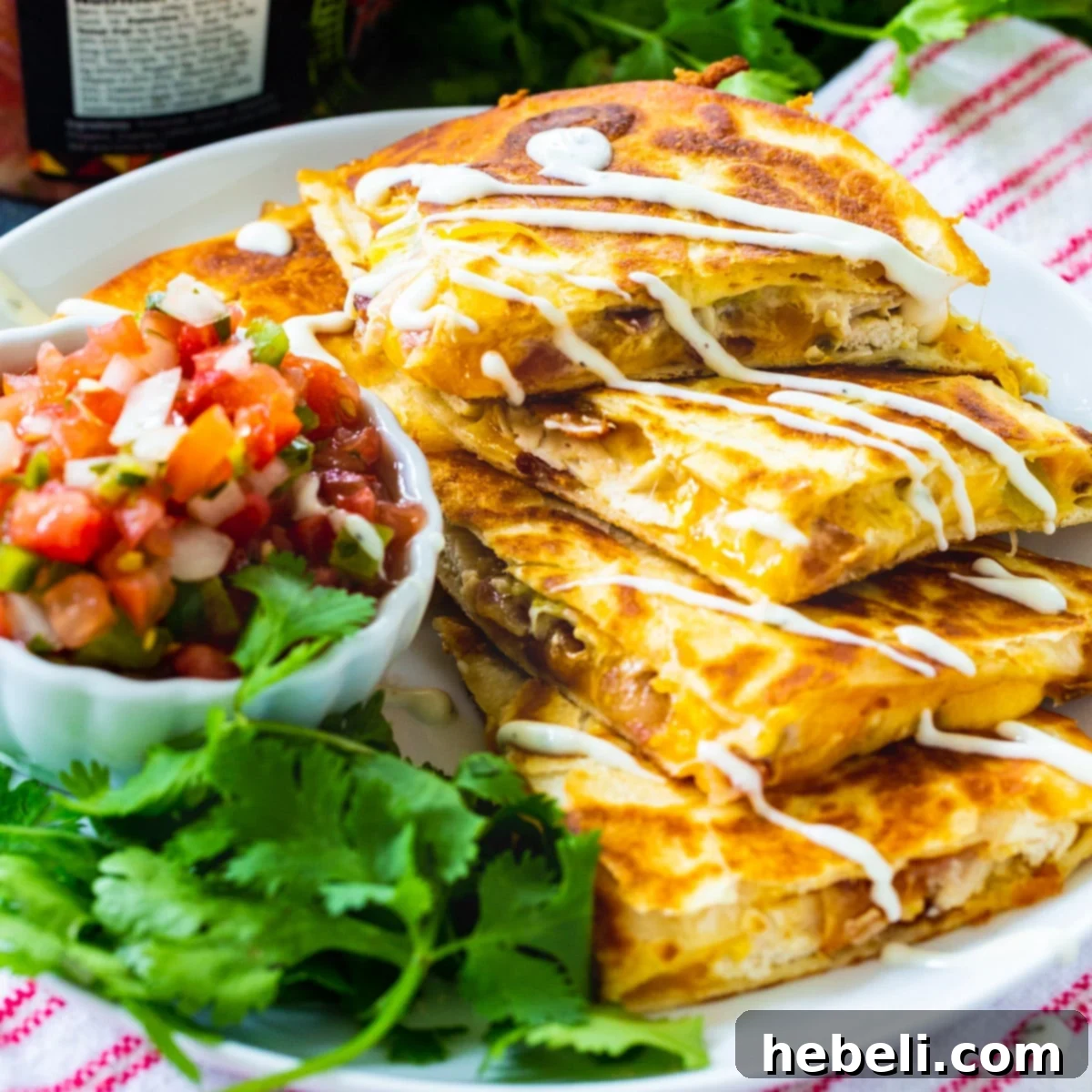 Crispy Chicken, Bacon and Ranch Quesadillas, cut into triangles and neatly stacked, ready to be served.