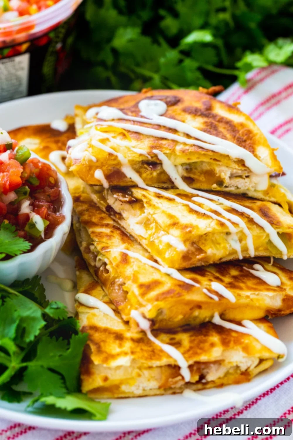 Chicken, Bacon and Ranch Quesadillas beautifully plated and drizzled with extra ranch dressing, highlighting them as a fantastic game day snack.
