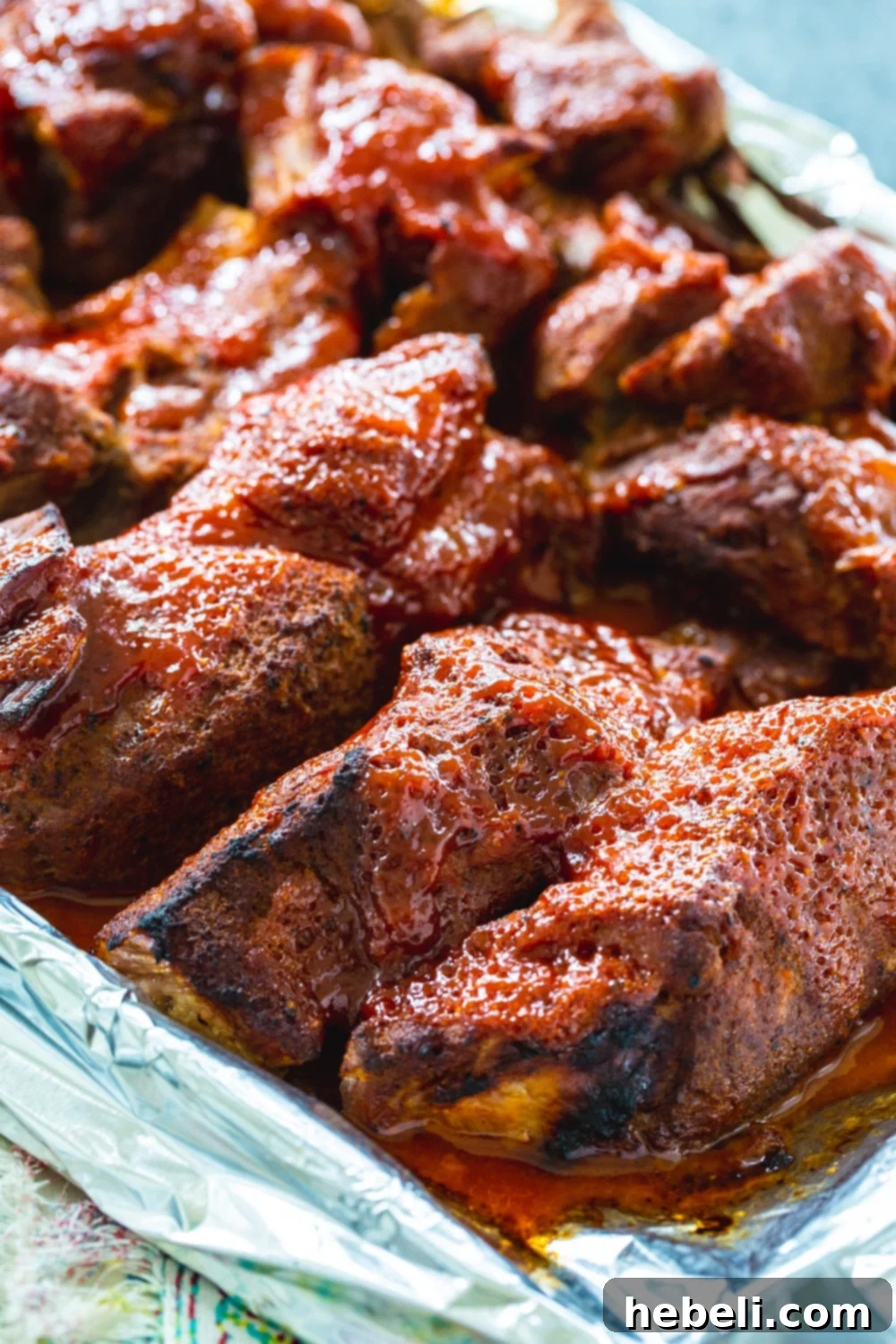 Raw country style ribs seasoned on a baking sheet, ready for cooking.
