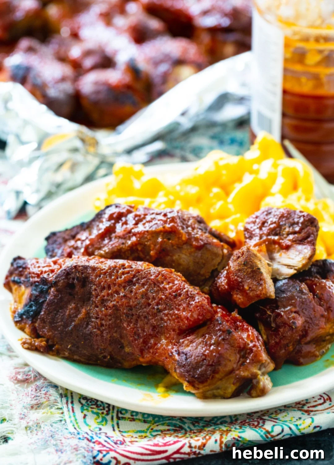 Plate of Instant Pot Country Style Ribs with mac and cheese, showing rich BBQ sauce.