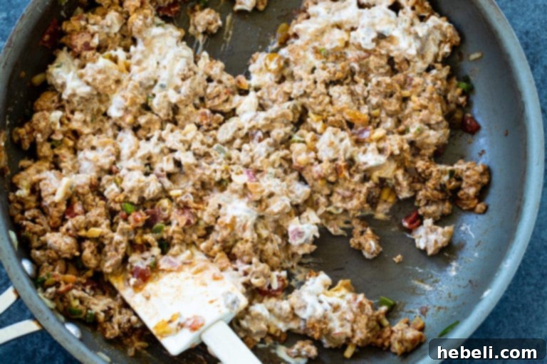 A close-up view of the Pork Picadillo Empanada filling, showcasing the rich ground pork, raisins, and spices.