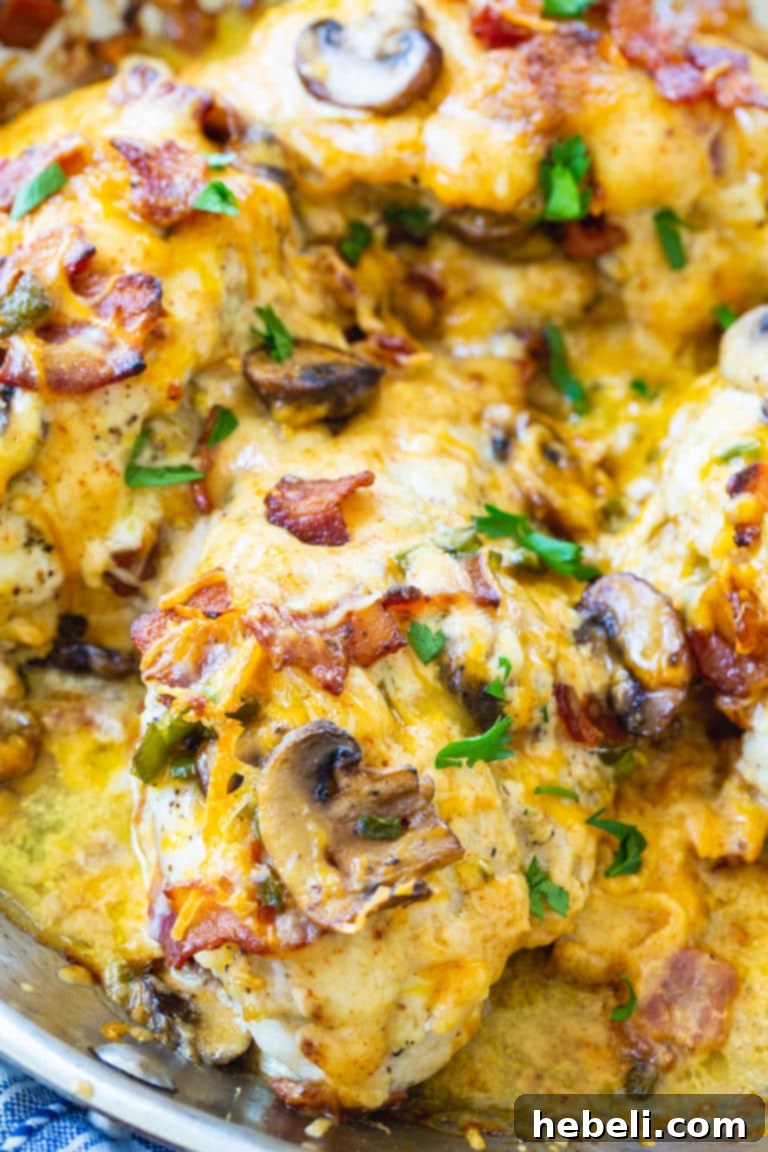 Ultimate Bacon Mushroom and Cheese Stuffed Chicken 5 Bacon, Mushroom, and Cheese Stuffed Chicken plated and garnished with fresh parsley.