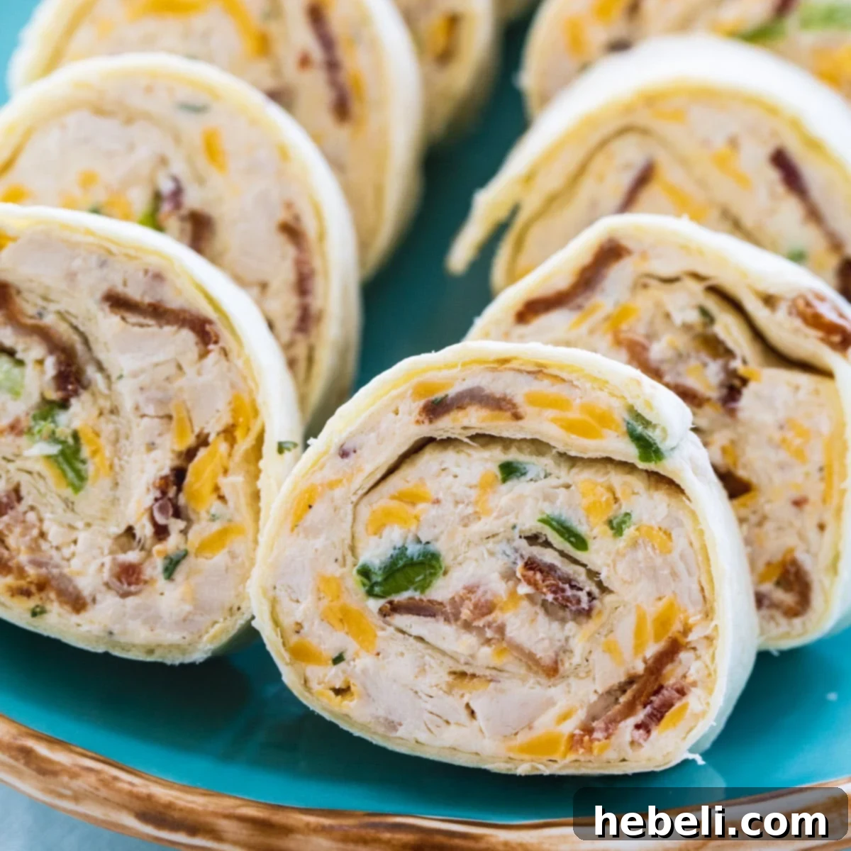 Delicious Chicken, Bacon, and Ranch Pinwheels arranged on a blue serving plate, ready to be enjoyed as a party appetizer.