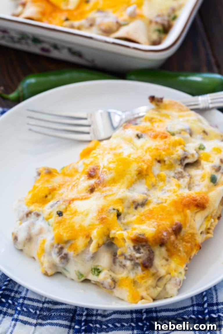 A close-up shot of the baked Southern Breakfast Enchiladas, showing the melted cheese and creamy gravy.