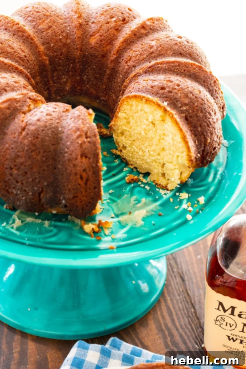 A stunning full view of the Kentucky Bourbon Butter Cake on a cake stand, glistening with glaze.