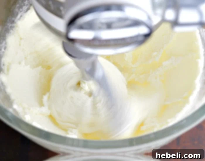 Close-up of butter and sugar being creamed together in a stand mixer bowl.