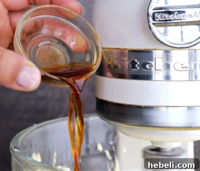 Vanilla extract being poured into the cake batter.