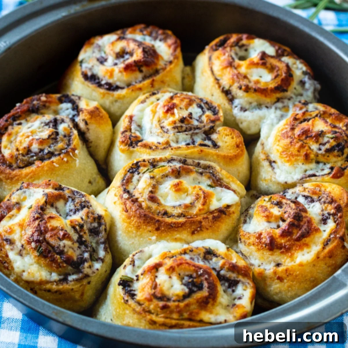 Golden Olive & Cheese Pinwheels 2 Easy Olive Cheese Rolls, freshly baked and golden brown in a round cake pan.