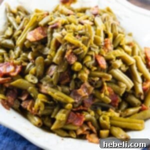 Canned green beans cooked in the slow cooker, garnished with bacon.