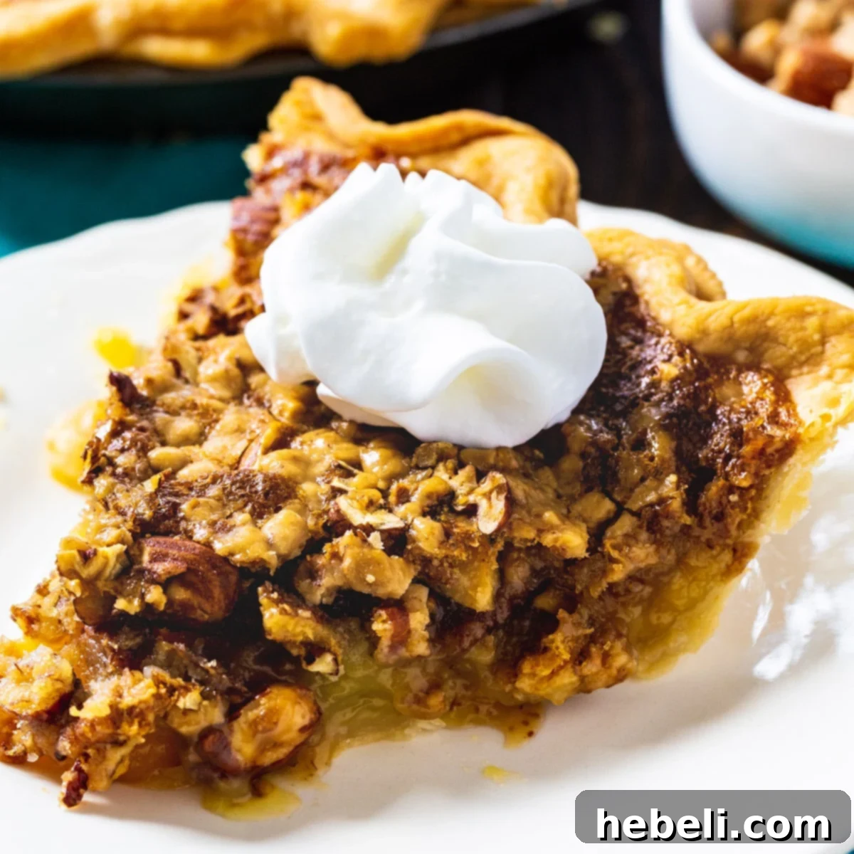 A delectable slice of Toffee Nut Pie served on a pristine white plate, showcasing its golden crust, gooey filling, and an abundance of toasted pecans and almonds. A true masterpiece of dessert.