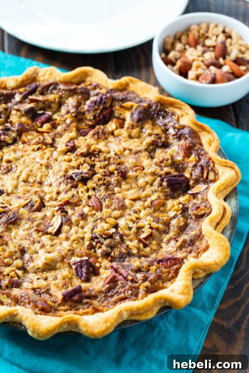 A beautiful, golden-brown Toffee Nut Pie, freshly baked in a flaky, refrigerated pie crust, ready to cool and be sliced. It's a rustic yet elegant dessert.