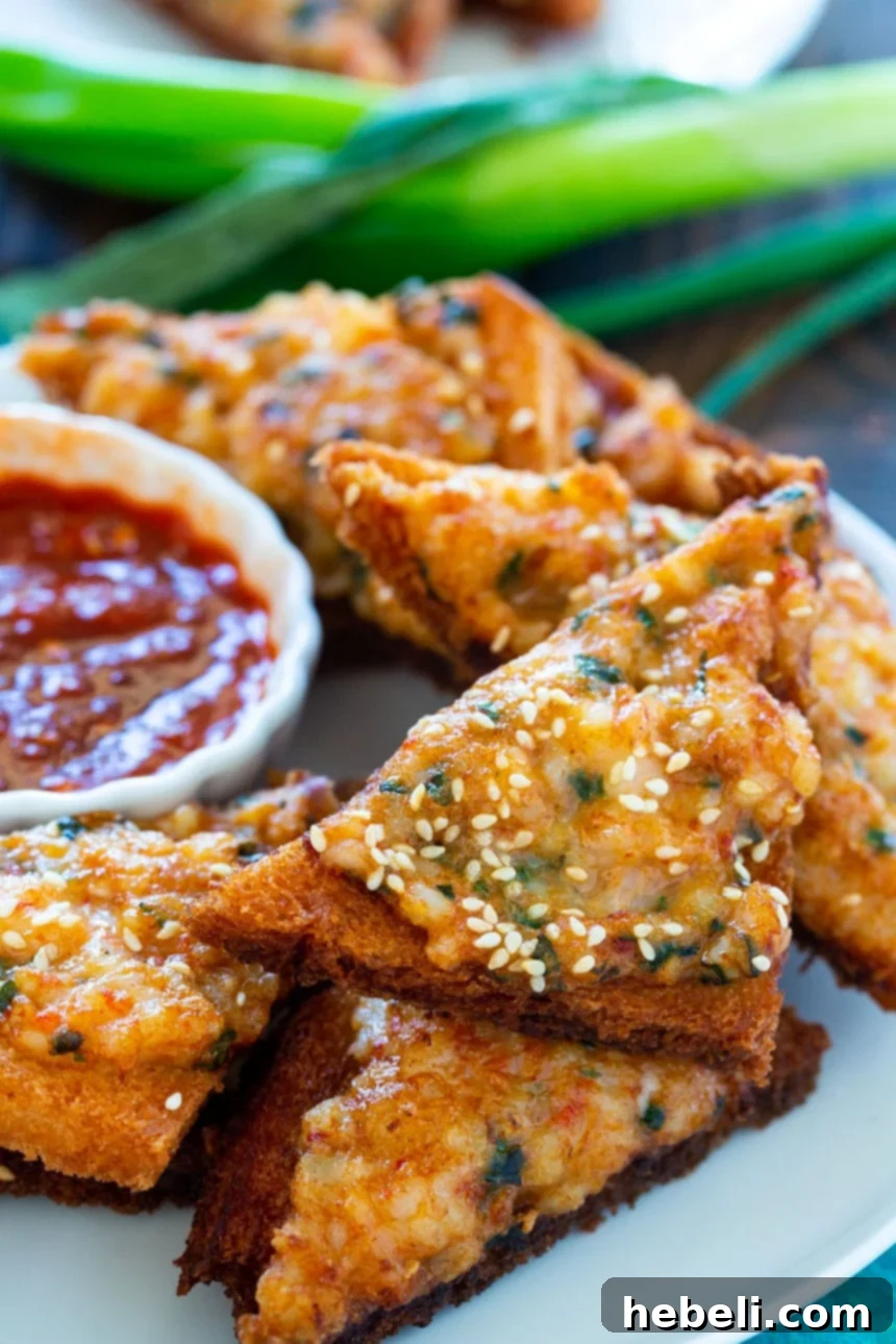 Close-up of golden and crispy Shrimp Toast, garnished with fresh green onion, showcasing its texture and deliciousness.