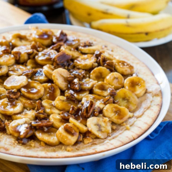 Bananas Foster Dessert Pizza, a sweet pizza topped with cream cheese, bananas, pecans, and caramel rum sauce