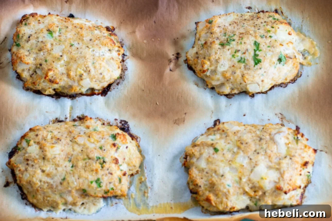 Close-up of raw seasoned ground chicken patties ready for baking.