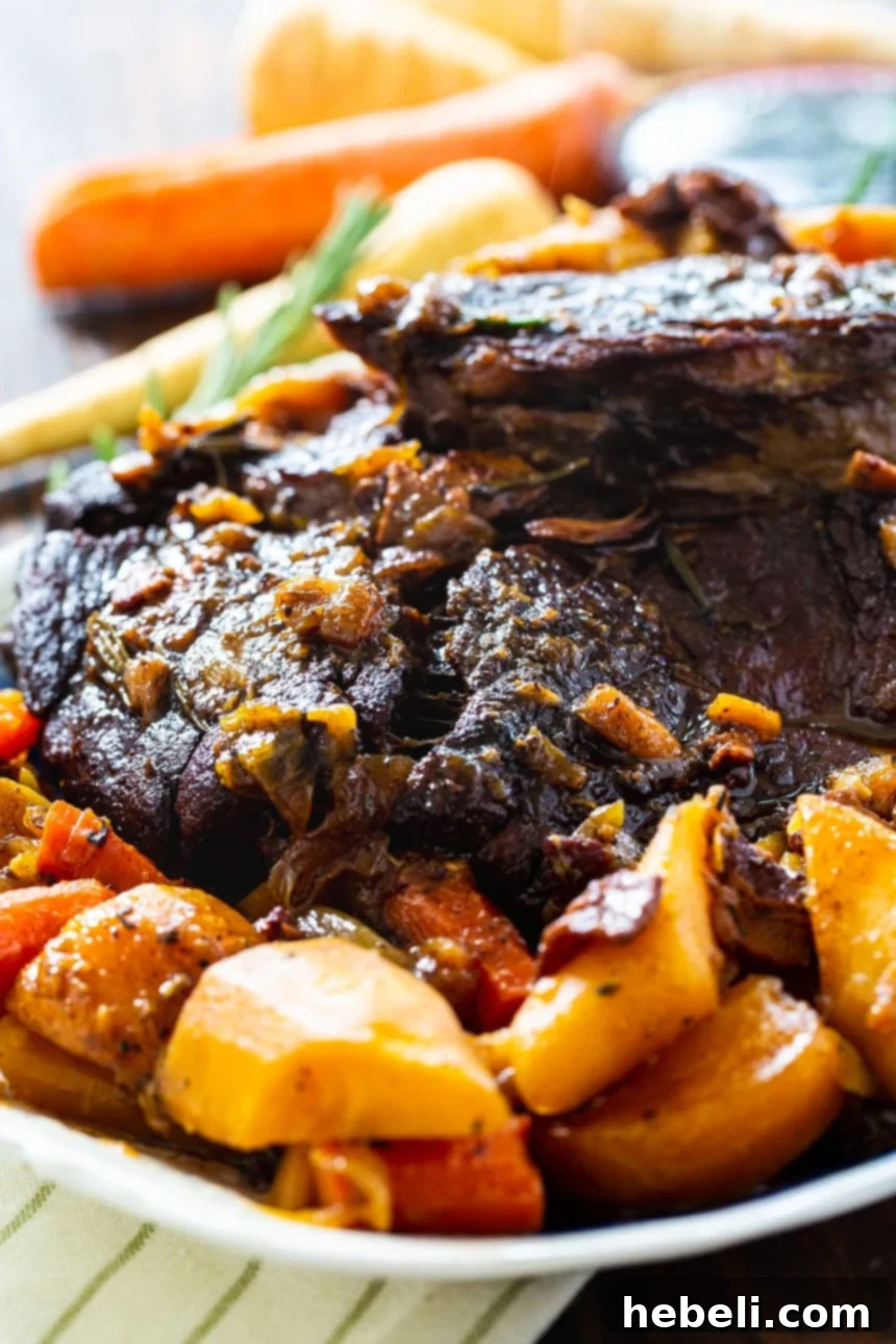 Close-up of a rustic Pot Roast with tender root vegetables, glistening with flavorful gravy.