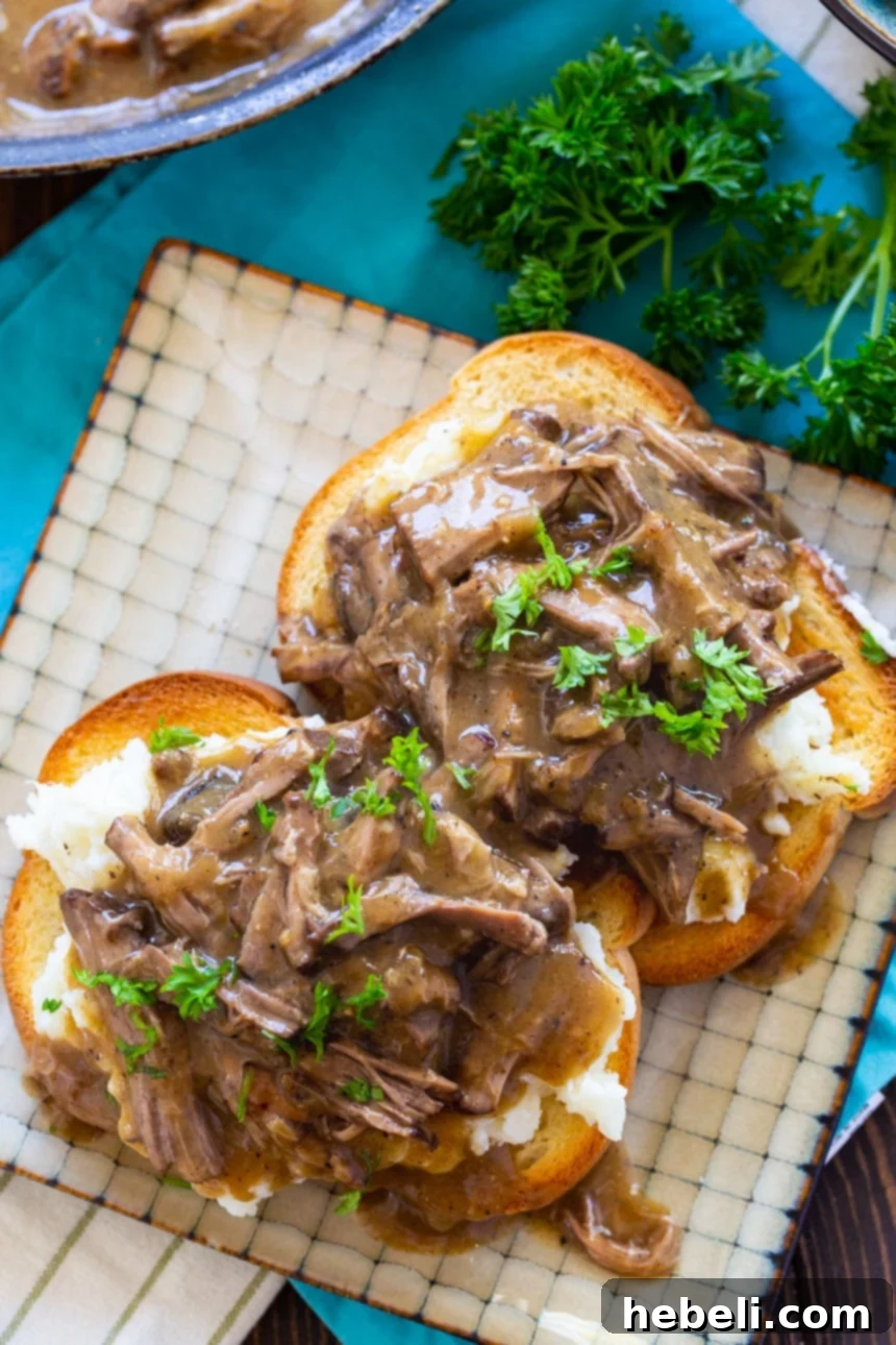 Delicious Hot Beef Sandwiches with Mashed Potatoes and Gravy on a rustic plate, ready to be served.