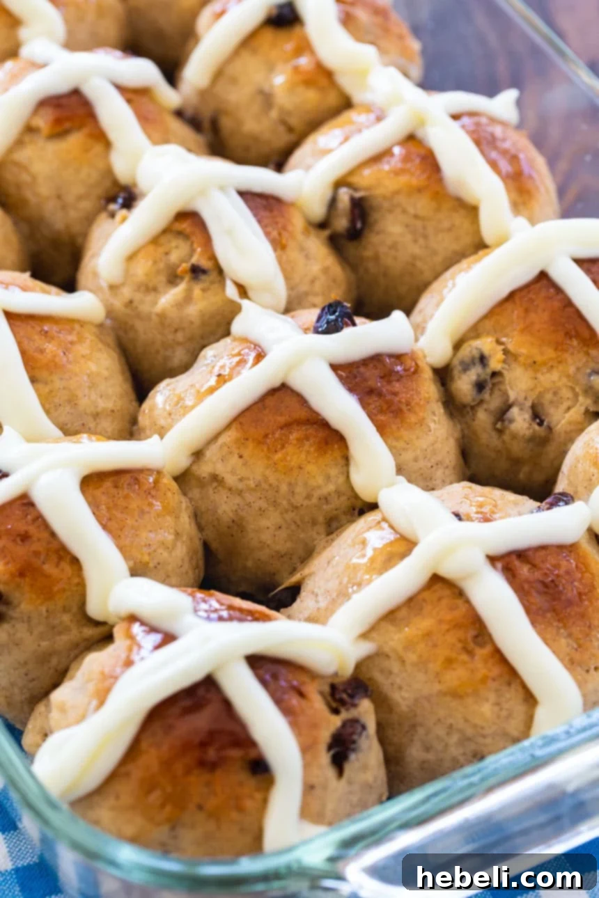 Freshly baked Hot Cross Buns cooling in a baking pan, ready for glazing.