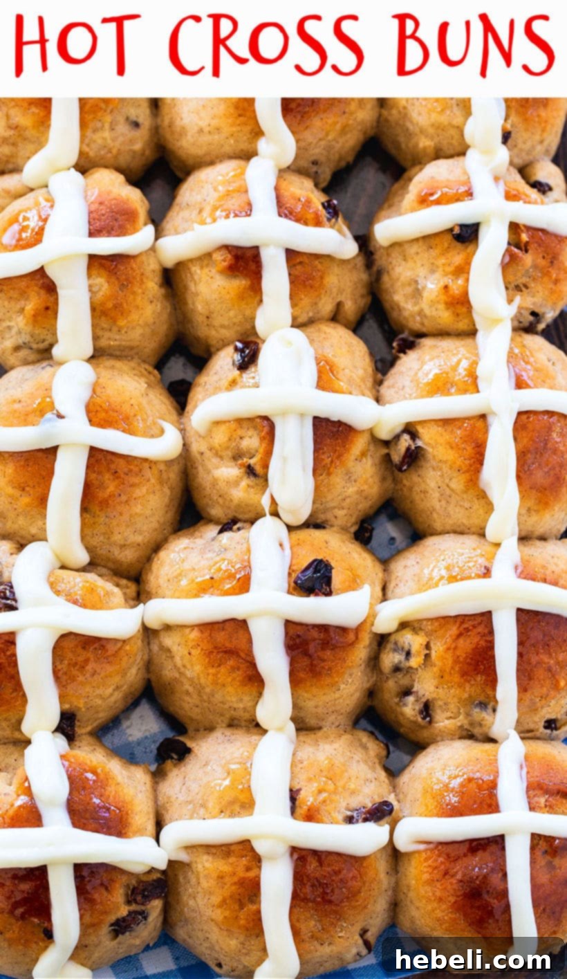 A close-up shot of a basket of Hot Cross Buns, showing off their texture and glaze.