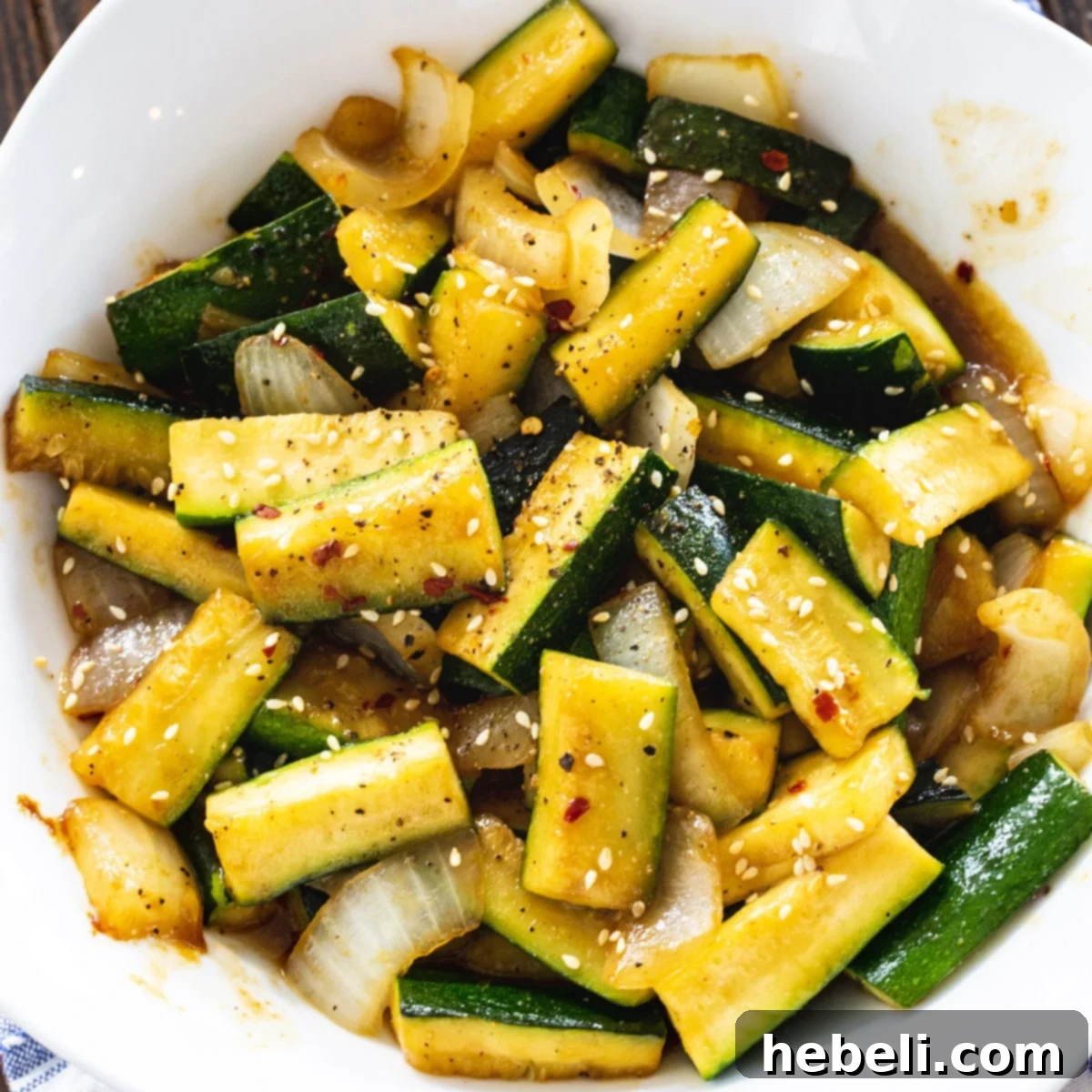 Japanese Zucchini Side Dish Japanese Zucchini in a white bowl, garnished with sesame seeds.