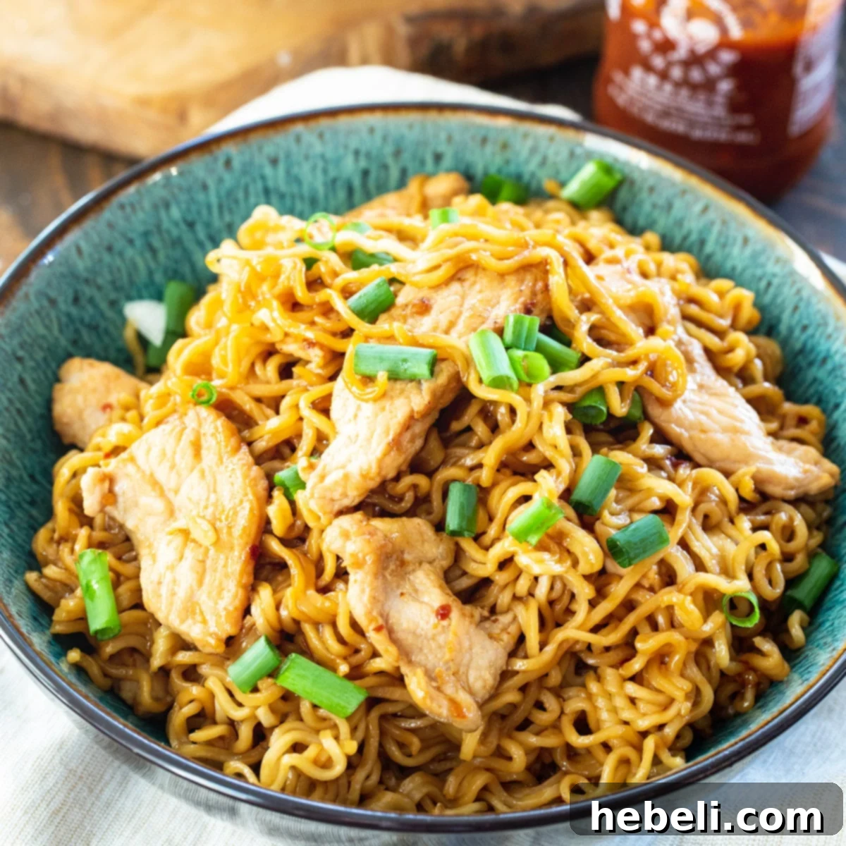 A tantalizing bowl of Spicy Pork Ramen, garnished with fresh green onions.