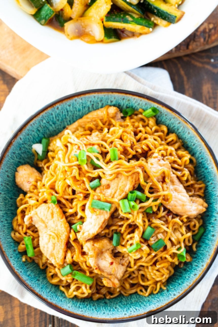 Close-up of perfectly cooked ramen noodles coated in a rich, spicy pork sauce.