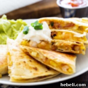 Sizzling Shrimp, Bacon and Corn Quesadillas 6 Shrimp, Bacon, and Corn Quesadilla on a plate with guacamole and salsa.