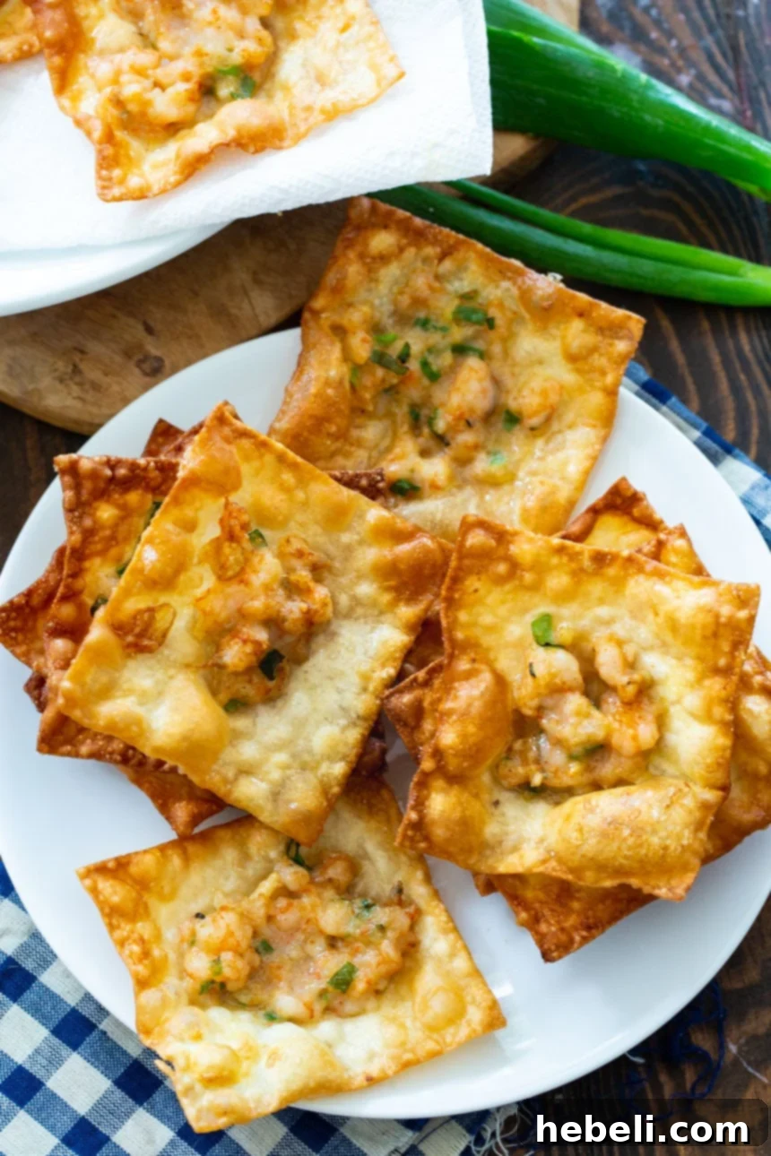 A generous, enticing pile of freshly fried, golden Shrimp Wonton Chips, garnished with green onions, ready to be devoured as a delightful appetizer.